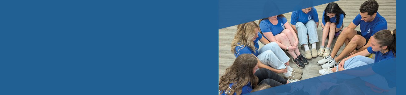 Camp Counsellors in blue shirts sitting in circle